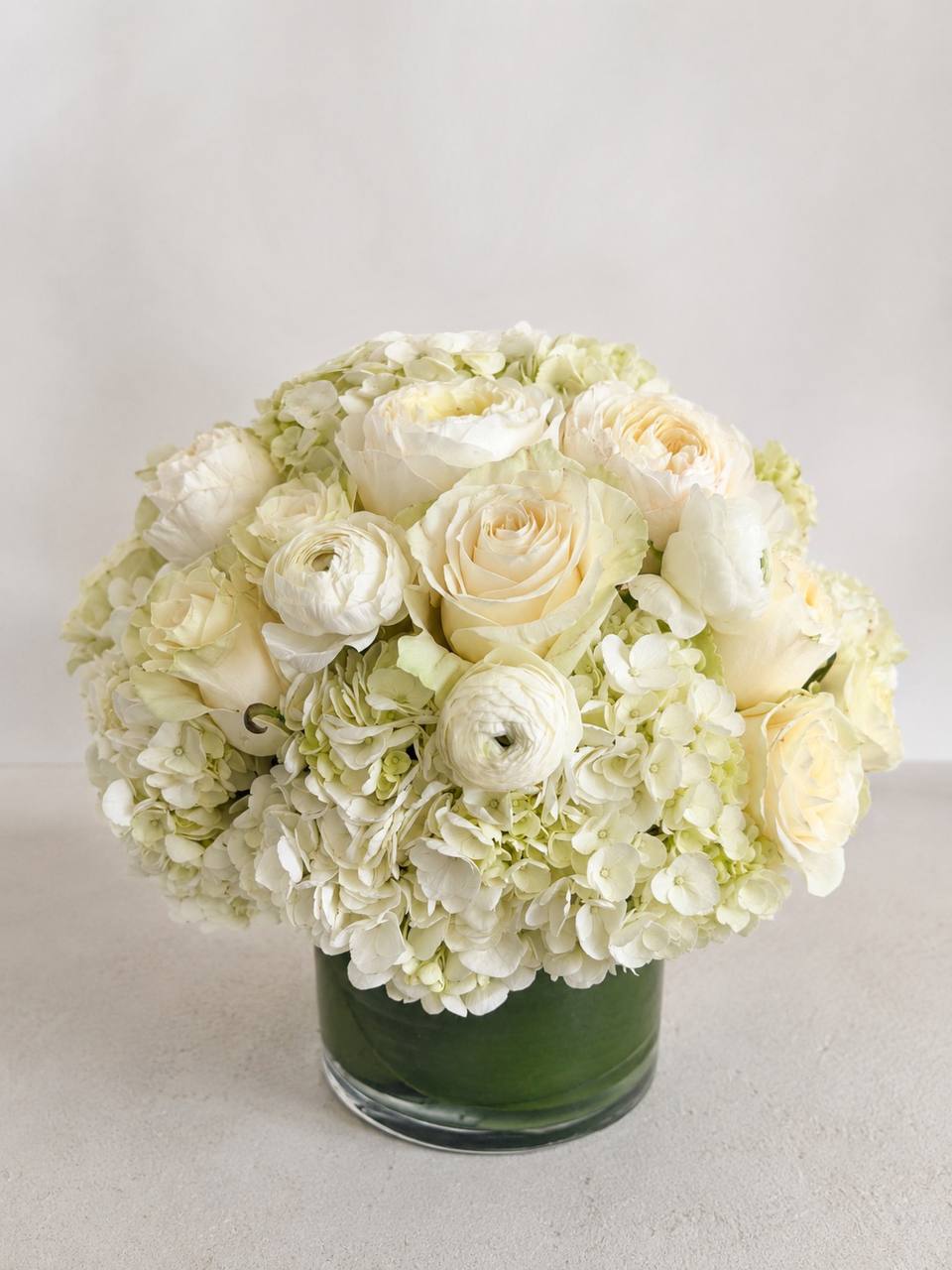 White Floral Arrangement in a Round Glass Vase